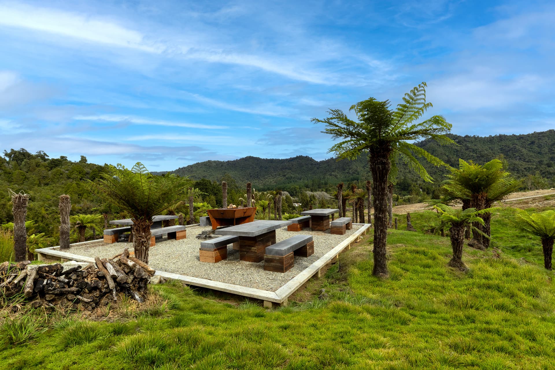 Barrel cabins in native rainforest at Kaiata with the West Coast ranges behind