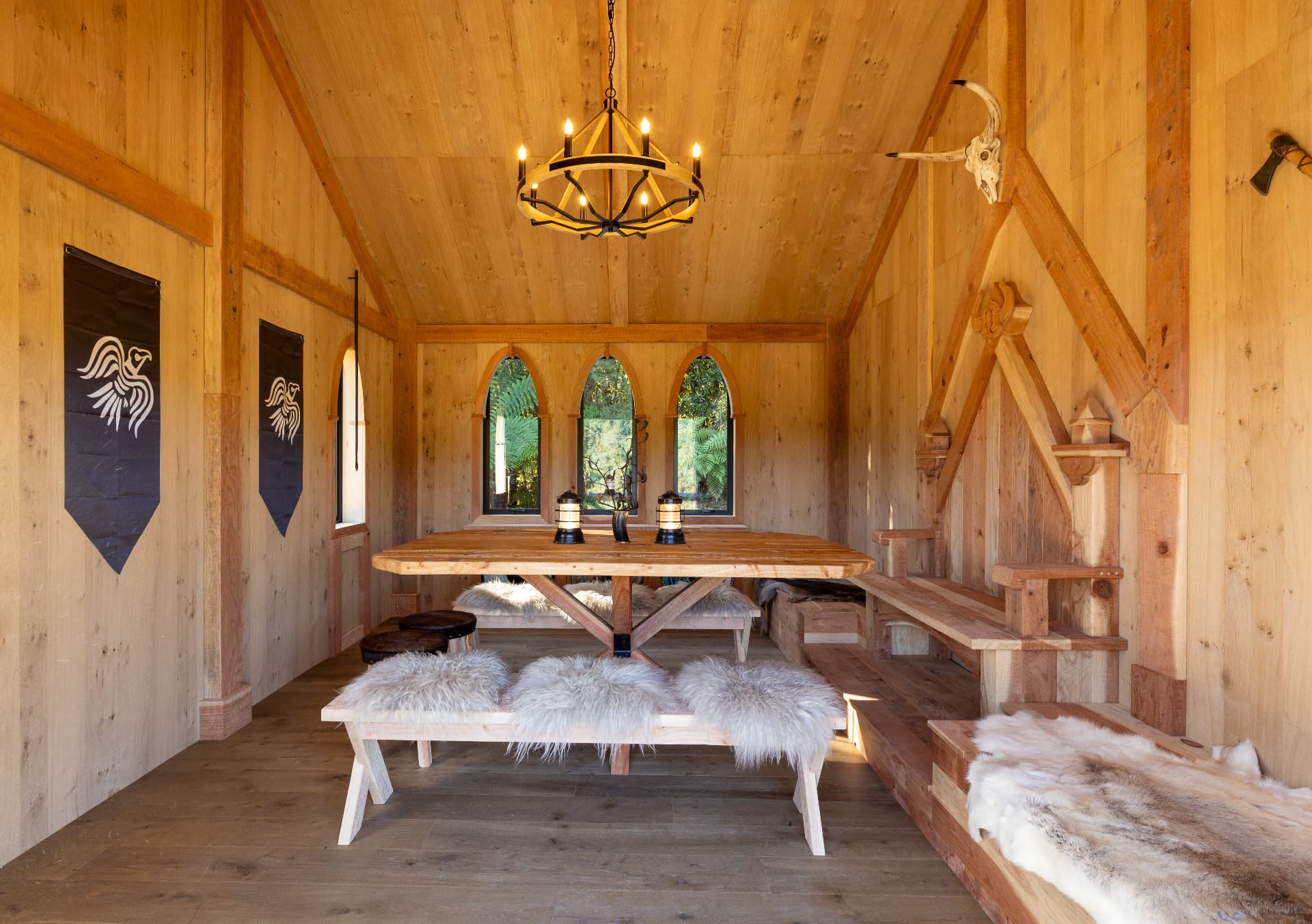 Inside the Great Hall with a long timber table, sheepskins and a wrought iron chandelier